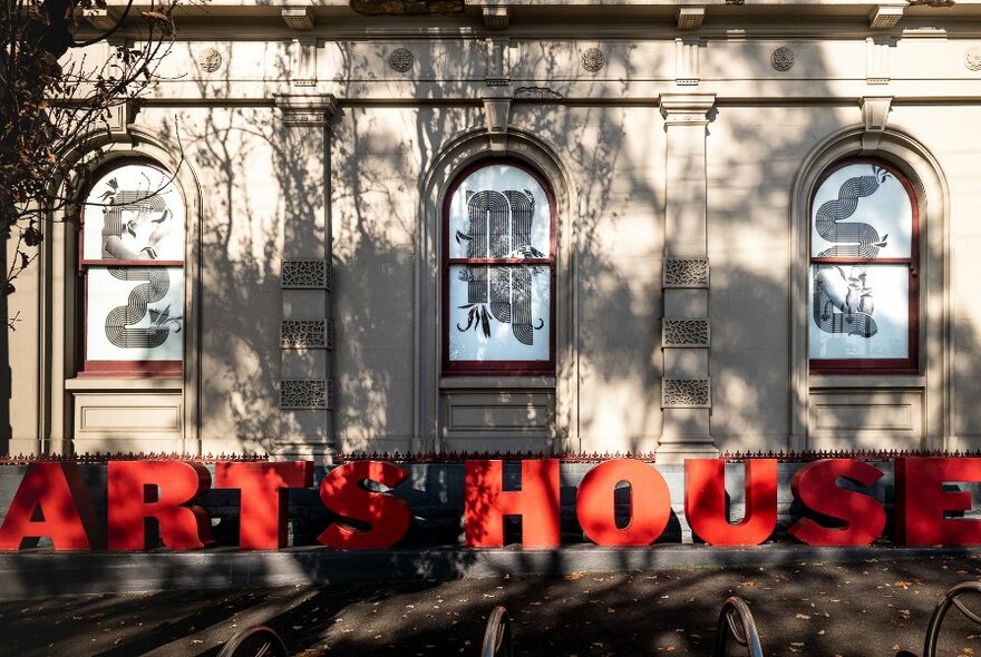 Arts House venue in Victorian building with pilasters and arched windows, the venue name spelled out in large red letters on the ground.