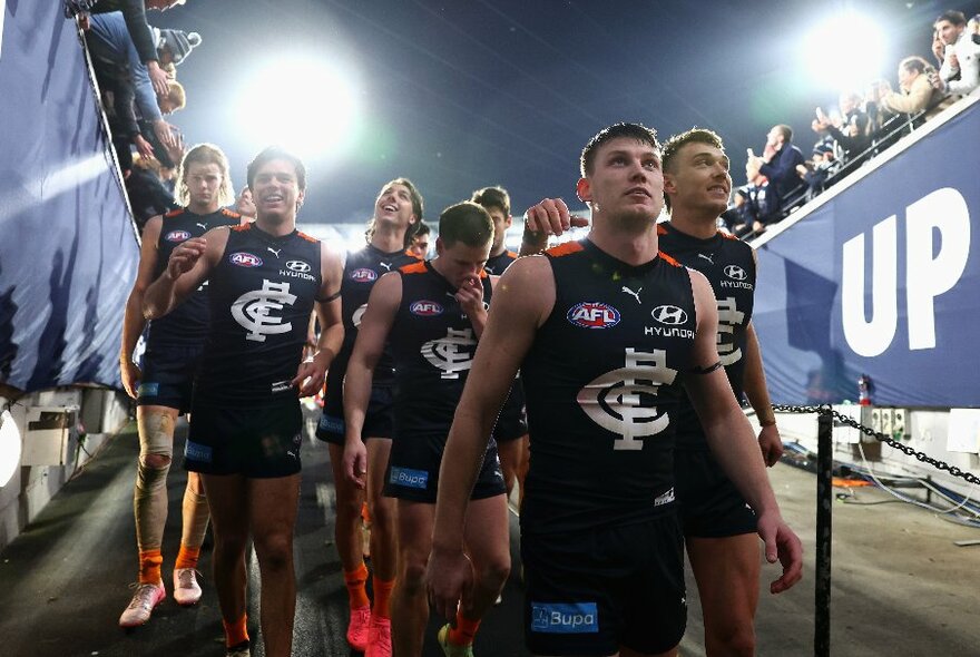Carlton players heading down to the rooms during a football match. 