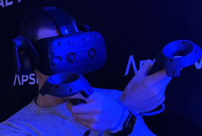 Person wearing VR goggles in a blue light room.