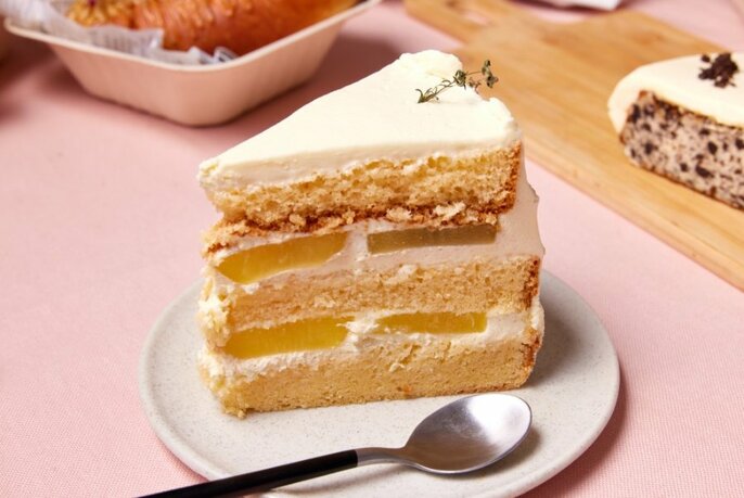 A plated-up slice of cake showing layers of filling and cream.