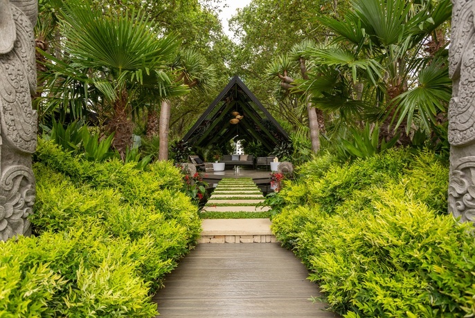 A Balinese-themed garden design with wooden walkway and A-frame seating area.