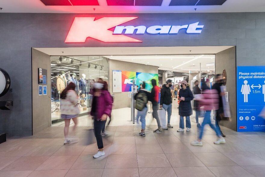 Shoppers walking through the large door into Kmart store.