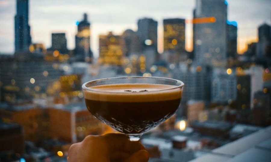 An espresso martini in front of a city skyline