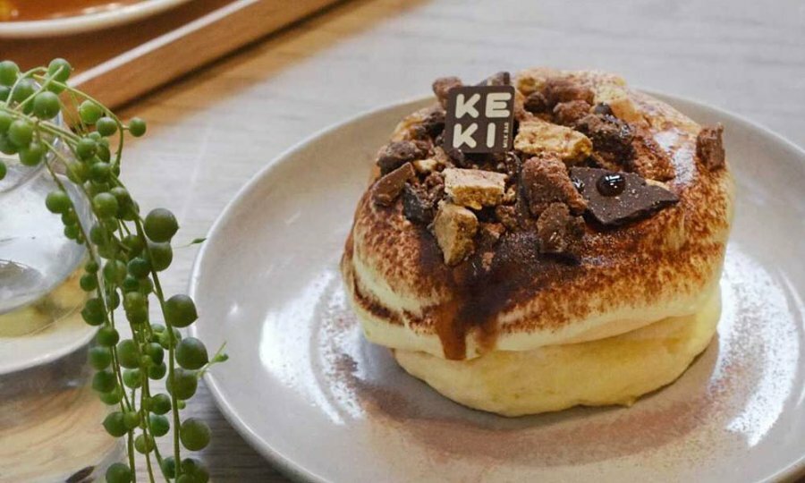 A souffle pancake covered in chocolate and served on a plate