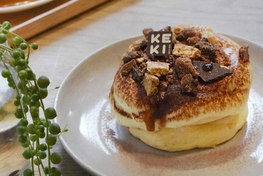 A souffle pancake covered in chocolate and served on a plate