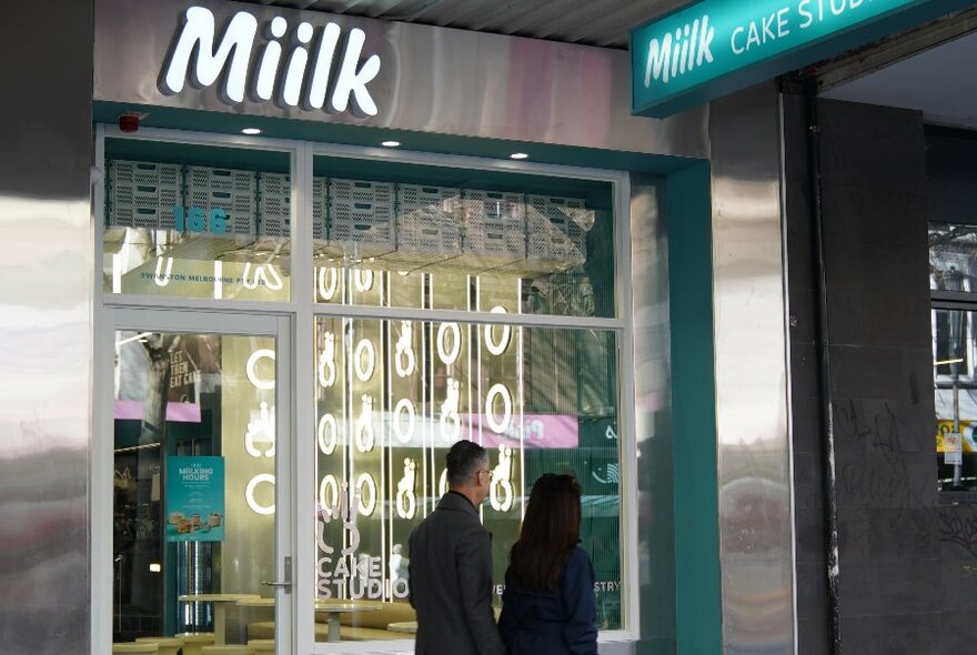 The exterior of a Miilk store with people wandering past. 