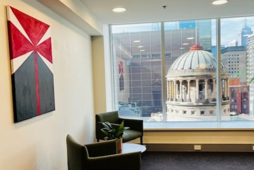 Abstract painting on the wall of an office with windows looking onto the Supreme Court dome.