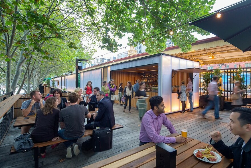 People dining at Arbory Bar and Eatery, next to Flinders Street Station, beside the Yarra River.
