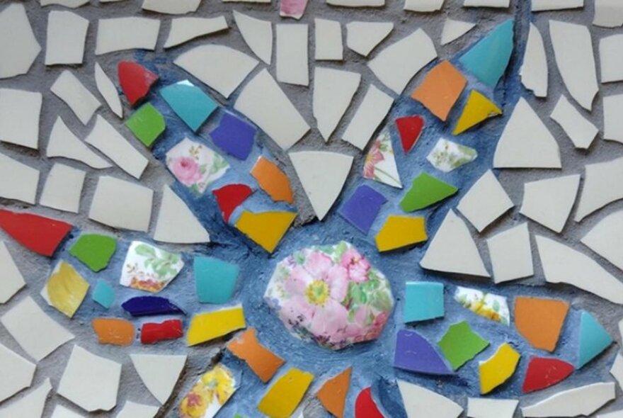 Detail of a mosaic made of broken tiles and pieces of broken ceramics.
