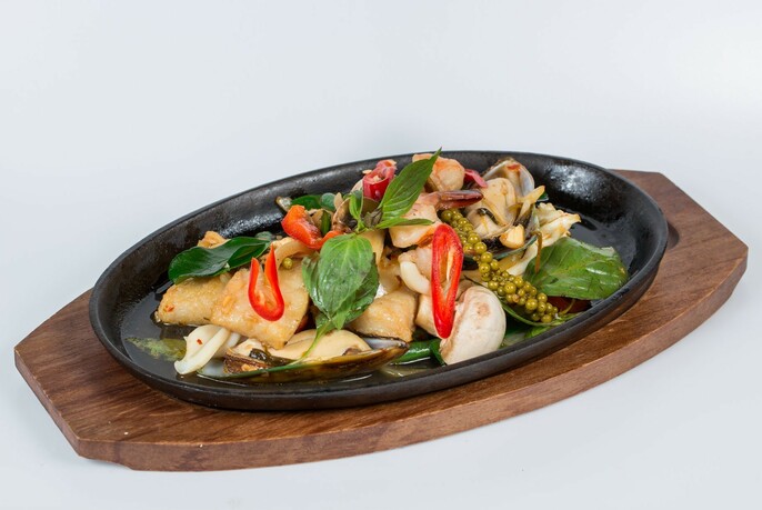 A sizzling plate of chicken with Thai basil and chilli.