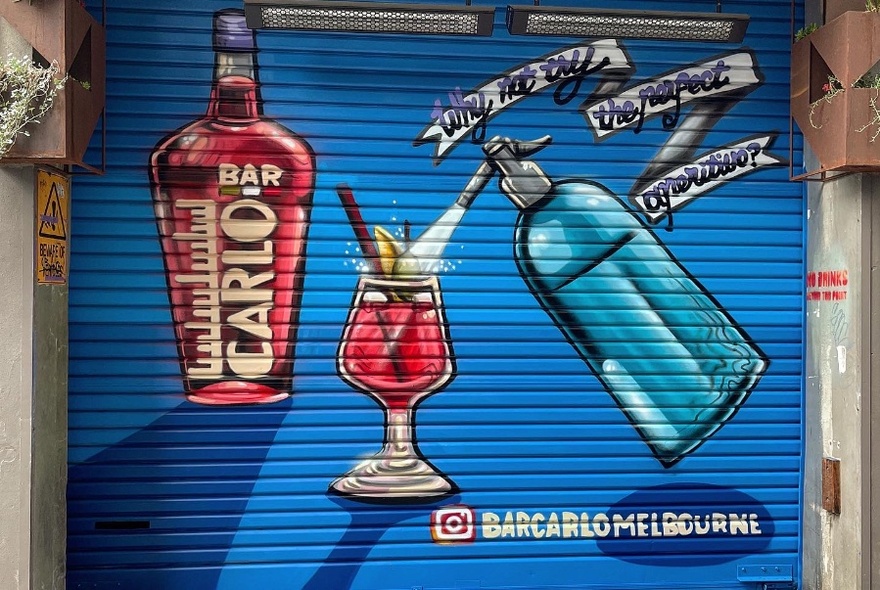 Blue garage door with graffiti of cocktail equipment. 