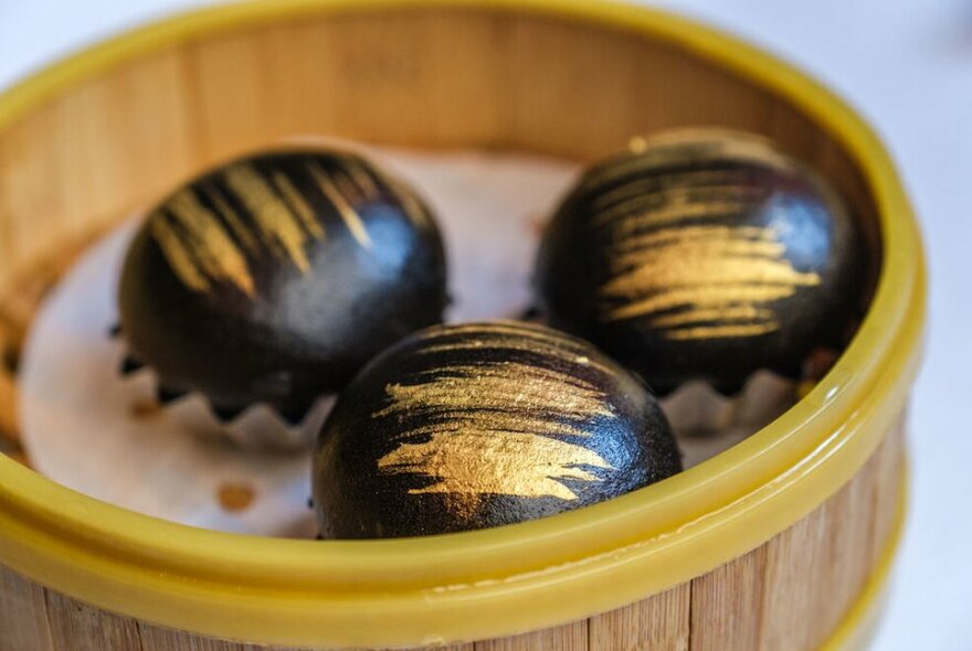 Black dumplings with gold streaks on them