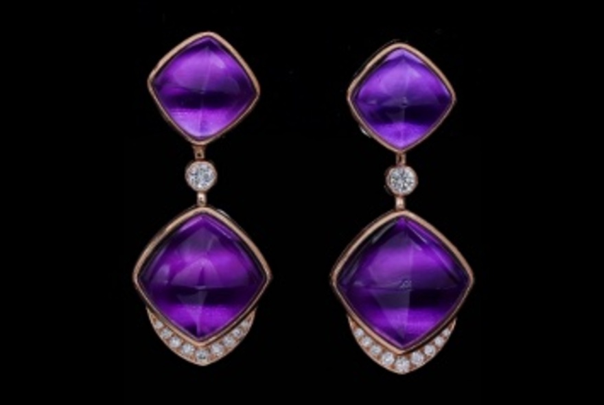 Purple amethyst drop earrings against a black background.