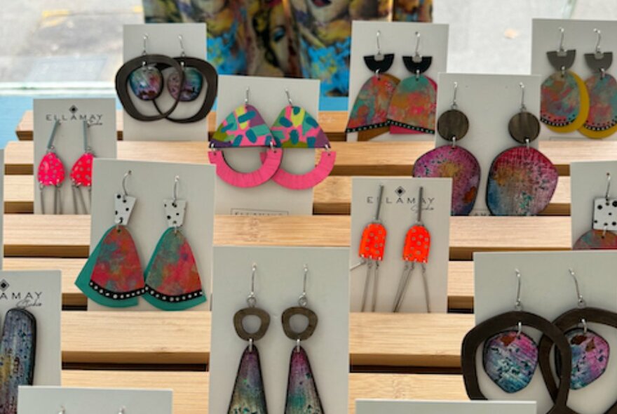 Earrings on display in a slotted rack in a retail space.