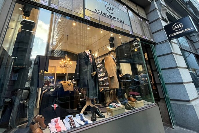 Exterior of menswear shop Anderson Hill showing a window display of garments and shoes.