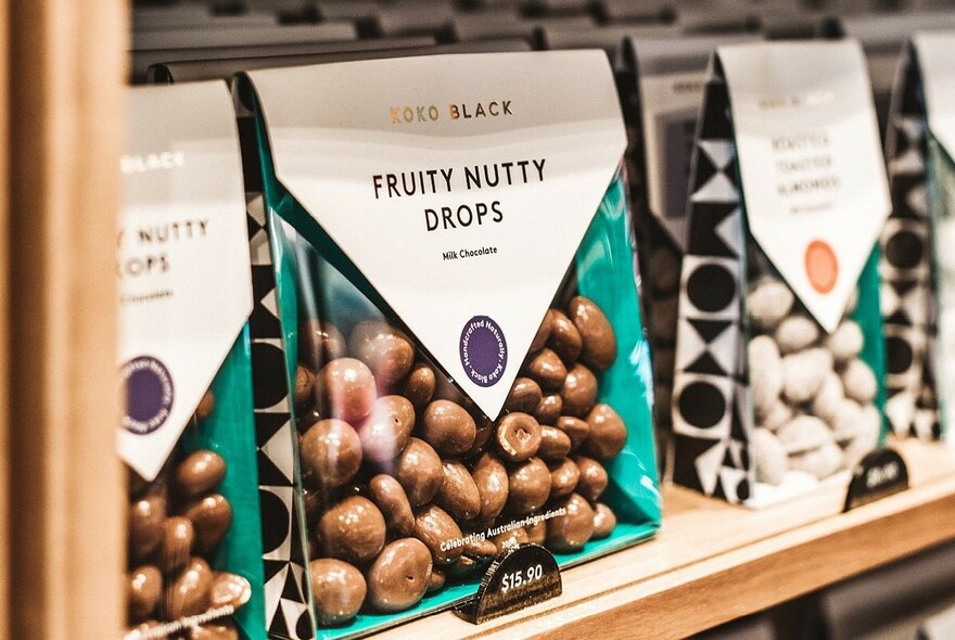 Bags of fruit and nut chocolates on a shelf.