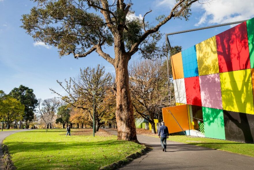 
The colourful cube exterior of the Melbourne Museum building surrounded by gardens.