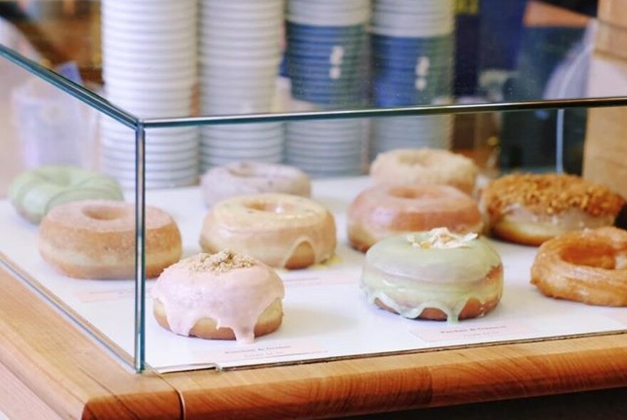 Iced doughnuts in a glass display cabinet.