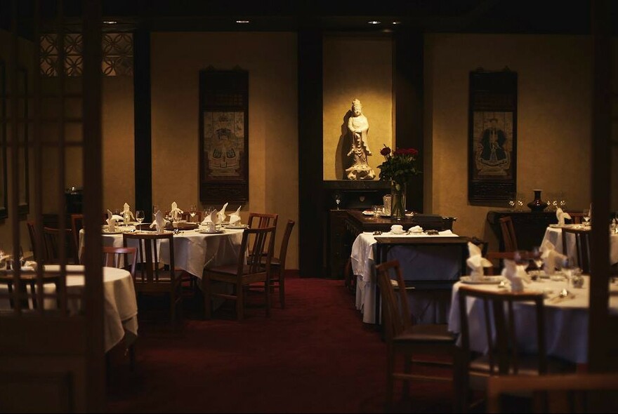 Sophisticated setting of up-market Chinese restaurant - dimly lit and with white table cloths.