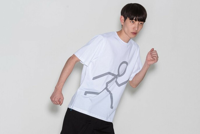 Model in running pose, wearing white T-shirt with grey stick figure in running pose.
