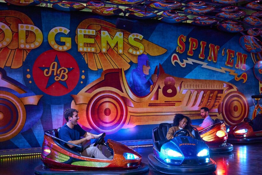 Three friends are playing on some dodgem cars