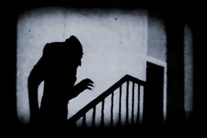 Still from Nosferatu, with the monster climbing the stairs.
