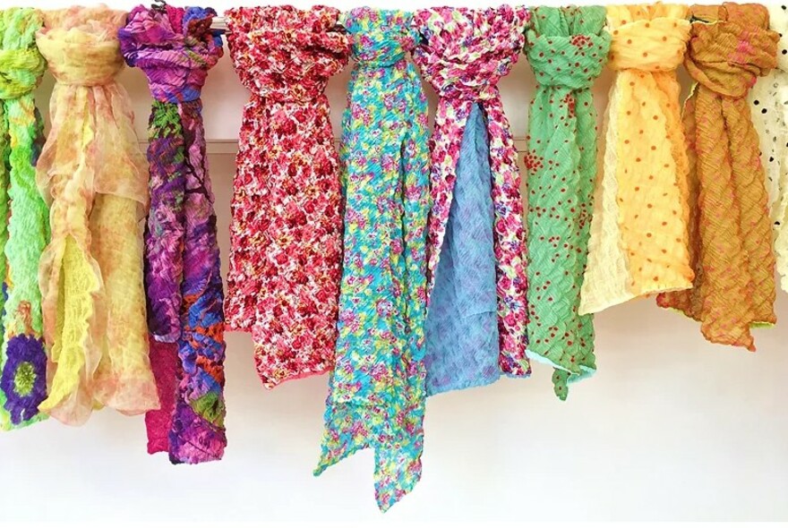 A row of brightly coloured floral summer scarves.