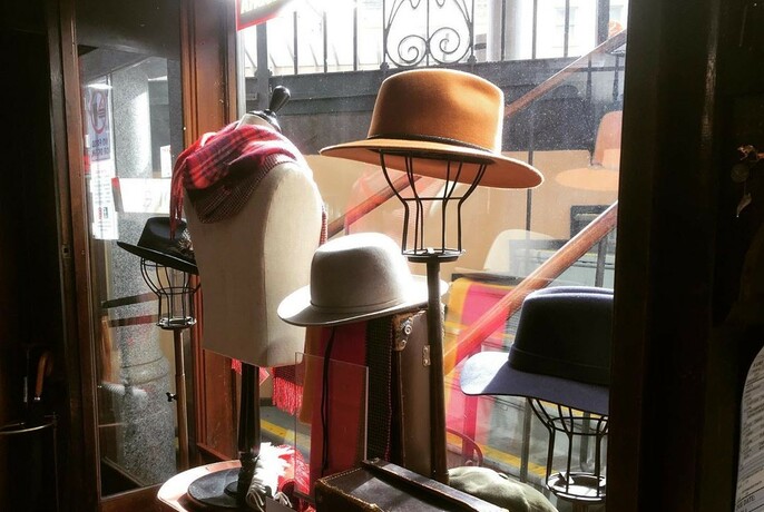 Hats for sale in a shop window.