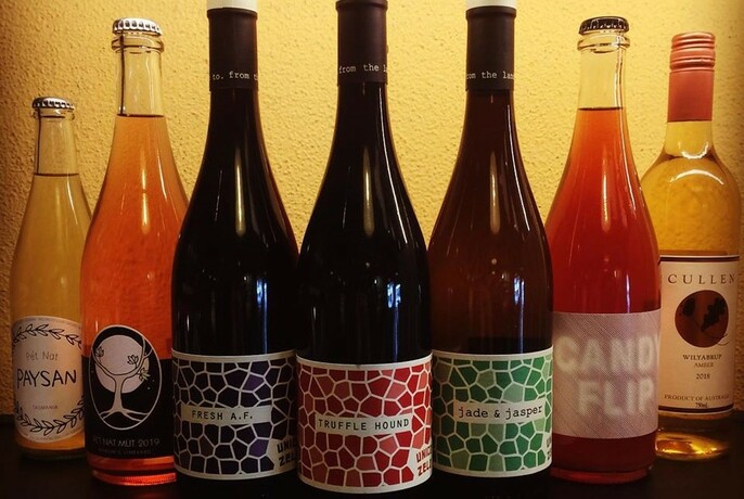 Seven assorted wines with colourful labels.