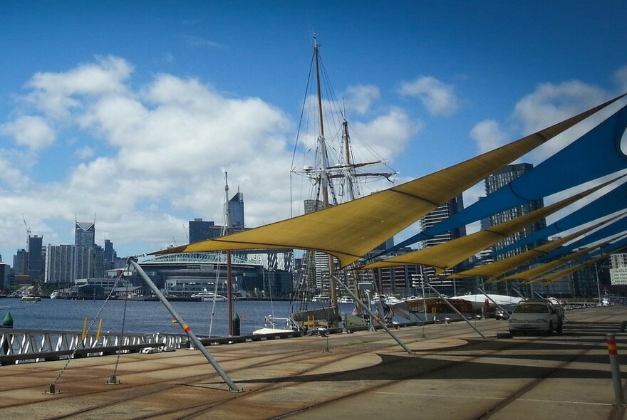 Wharf with boat moored and view of Melbourne city buildings in the background.