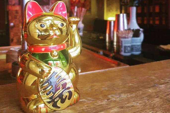 Golden lucky Chinese cat figure on a bar.