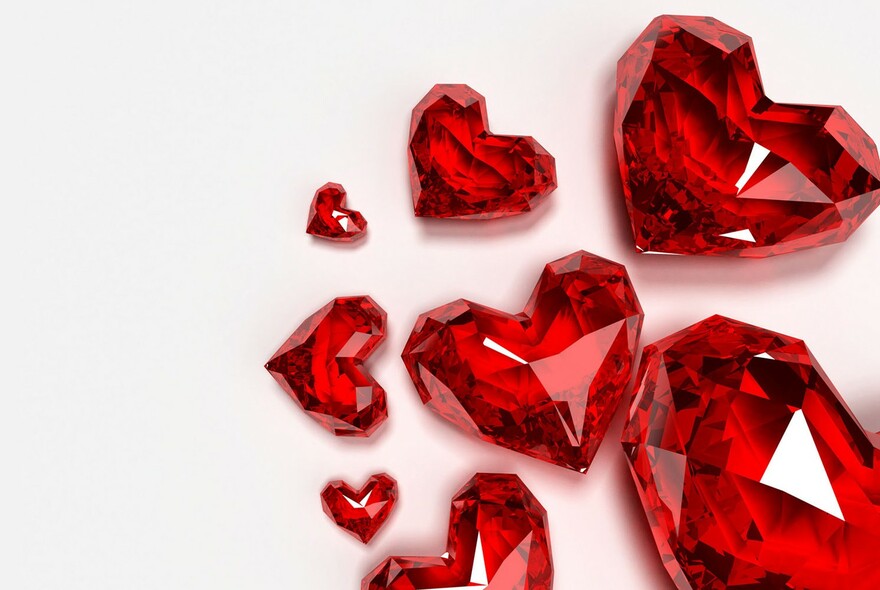Red heart-shaped cut gemstones on a white background.