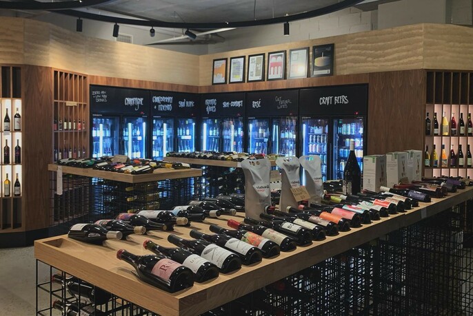 Interior of Act of Wine showing bottles on display and fridges in the background.