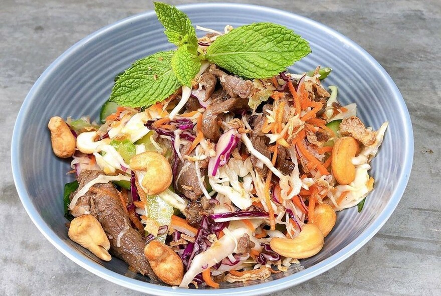 Bowl of beef, cashews and shredded cabbage.