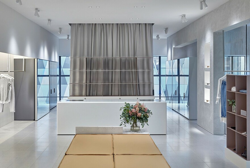 White shop interior with grey curtains and minimalist furniture.