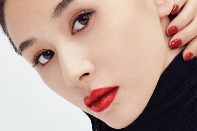 Model's face with red lipstick and nail polish, and eyeliner.
