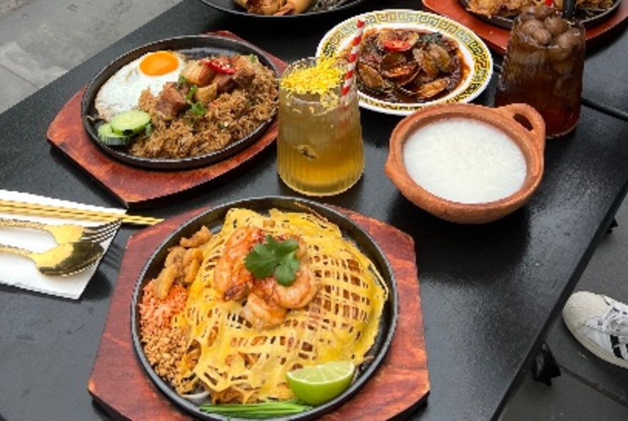 A selection of Thai-style dishes on a black table.