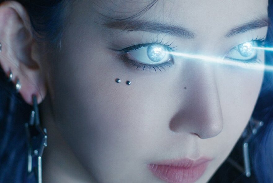 Female Korean pop star with silver earrings and dots beneath one eye, with laser lines projecting from both eyes.