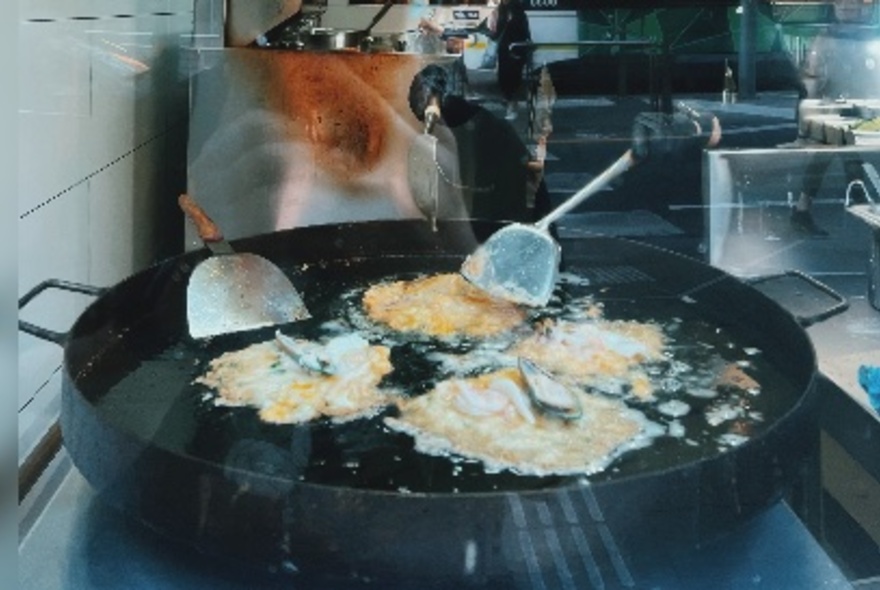 A large pan with four omelettes cooking. 