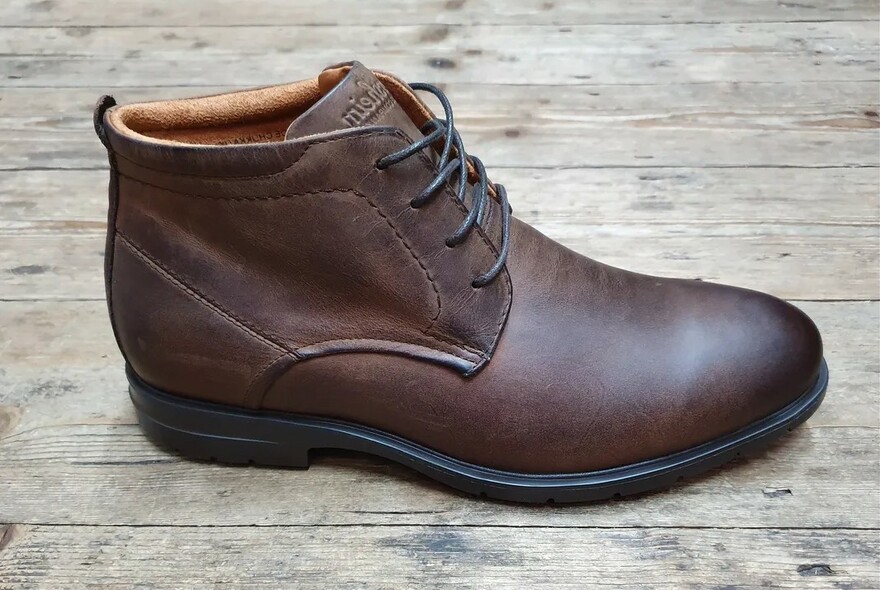One lace-up brown leather boot.