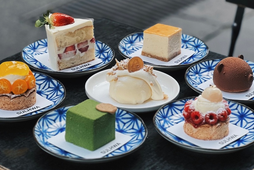 Selection of different mini cakes served on blue and white ceramic plates.