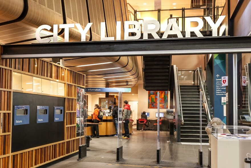 The entrance to City Library, with reception desk and stairs.