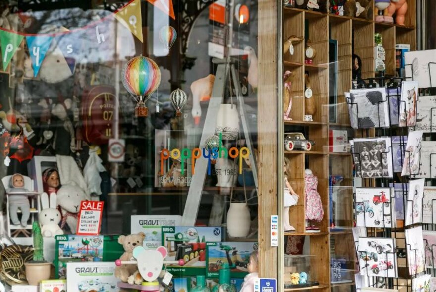 Glass window front of Poppyshop, with assorted toys, cards and products for sale.