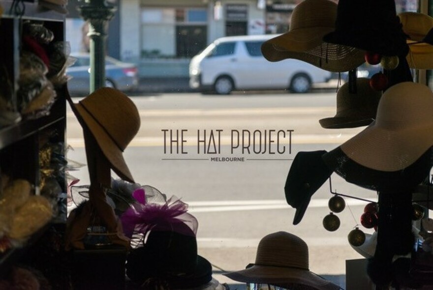 Shopfront with hats around the words The Hat Project on window.