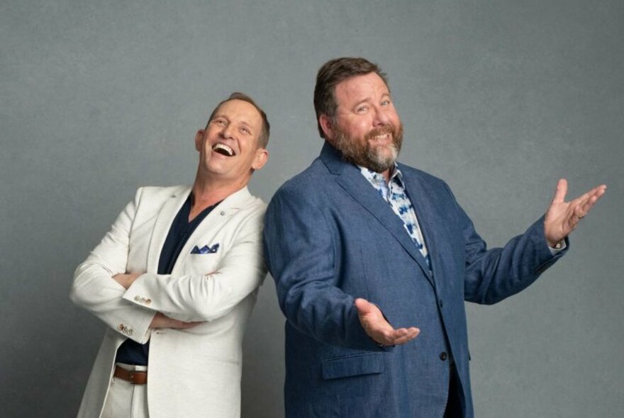 Actors Shane Jacobson and Todd McKenney smiling and standing back to back.