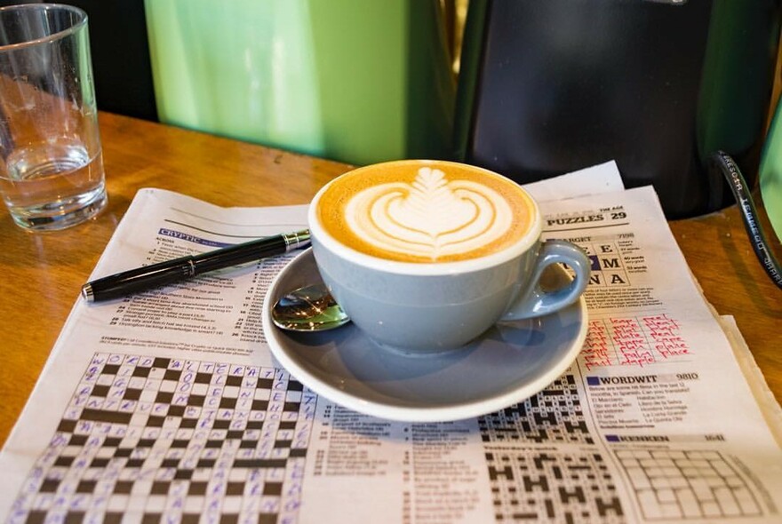Cup of coffee on a newspaper crossword.