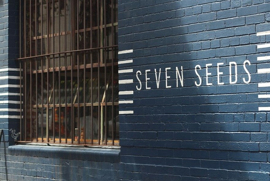 Exterior wall of Seven Seeds café showing their branding.
