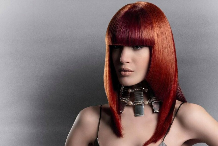 Red haired woman with a sleek haircut. 