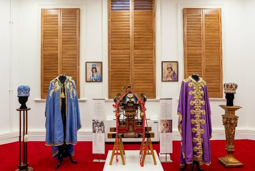 Room displaying official robes and regalia on mannequins.