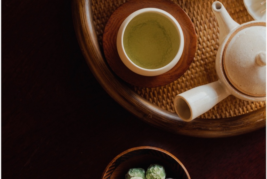 A Japanese tea set viewed from above, resting on a woven wooden tray.